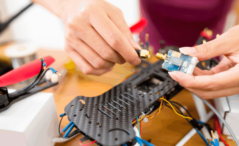 un homme bricole un chassis de drone