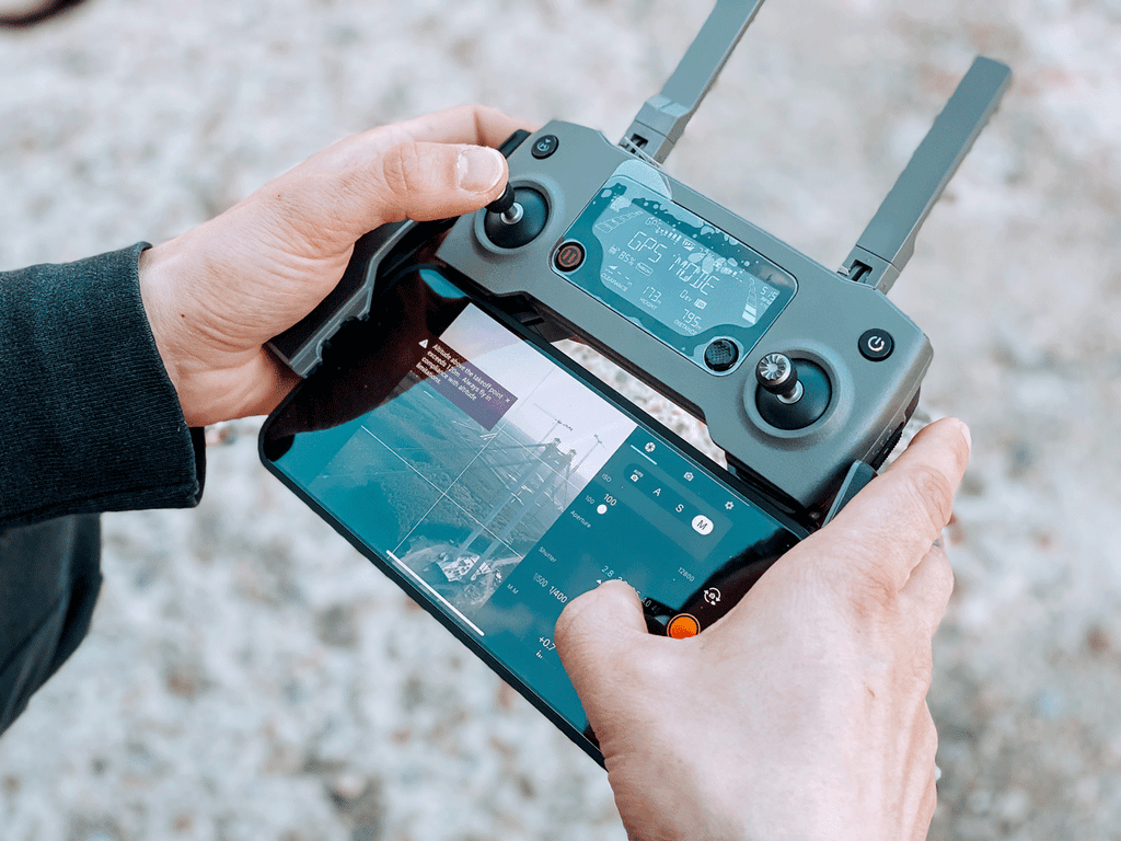 Un homme avec sa télécommande de drone en main